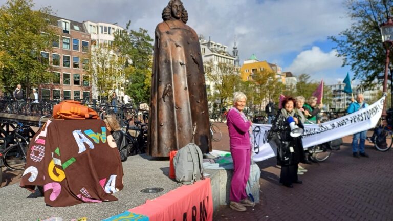 XR-rebellen doen een die-in bij het klimaatalarm bij het Spinozamonument